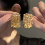 Lange Ohrringe mit geschwungenem Stab und Quaste – Gold